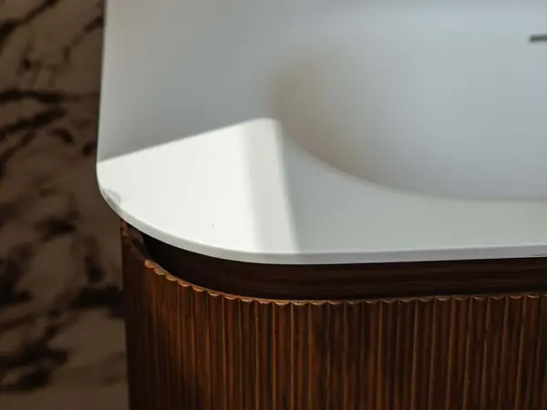 Baignoire habillée d’un tablier en noyer cannelé et marbre veiné