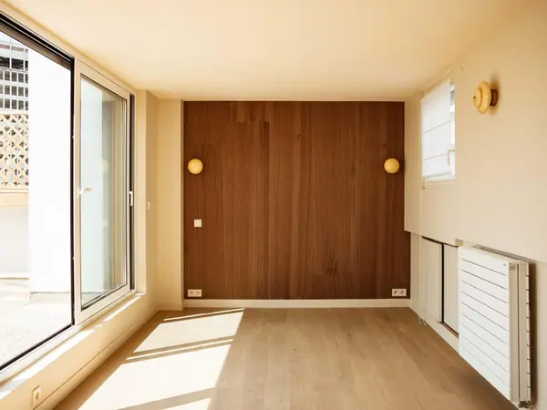 Chambre rénovée avec tête de lit en panneaux de noyer et parquet clair