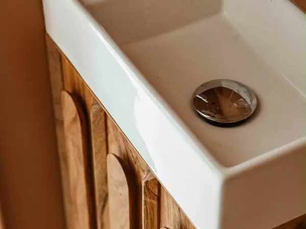 Lave-mains posé sur un meuble en noyer cannelé