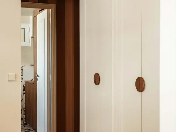Placards blancs sur mesure avec poignées rondes en bois