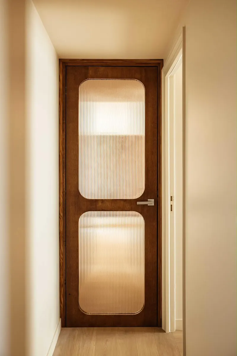 Porte intérieure en bois aux vitrages arrondis en verre cannelé