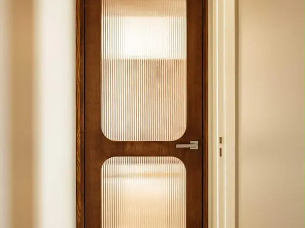 Porte intérieure en bois aux vitrages arrondis en verre cannelé
