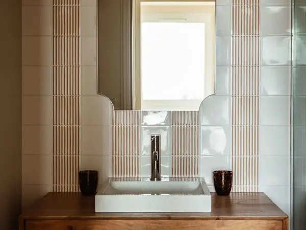 Salle d’eau rénovée avec meuble vasque en noyer et miroir festonné