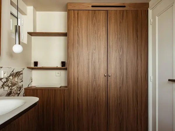 Salle de bain avec niche à étagères et grand placard en noyer