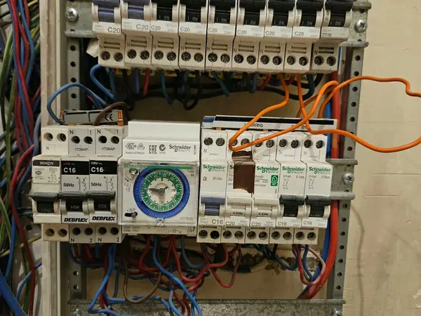 Armoire électrique avec disjoncteurs, horloge et contacteurs en cours de câblage