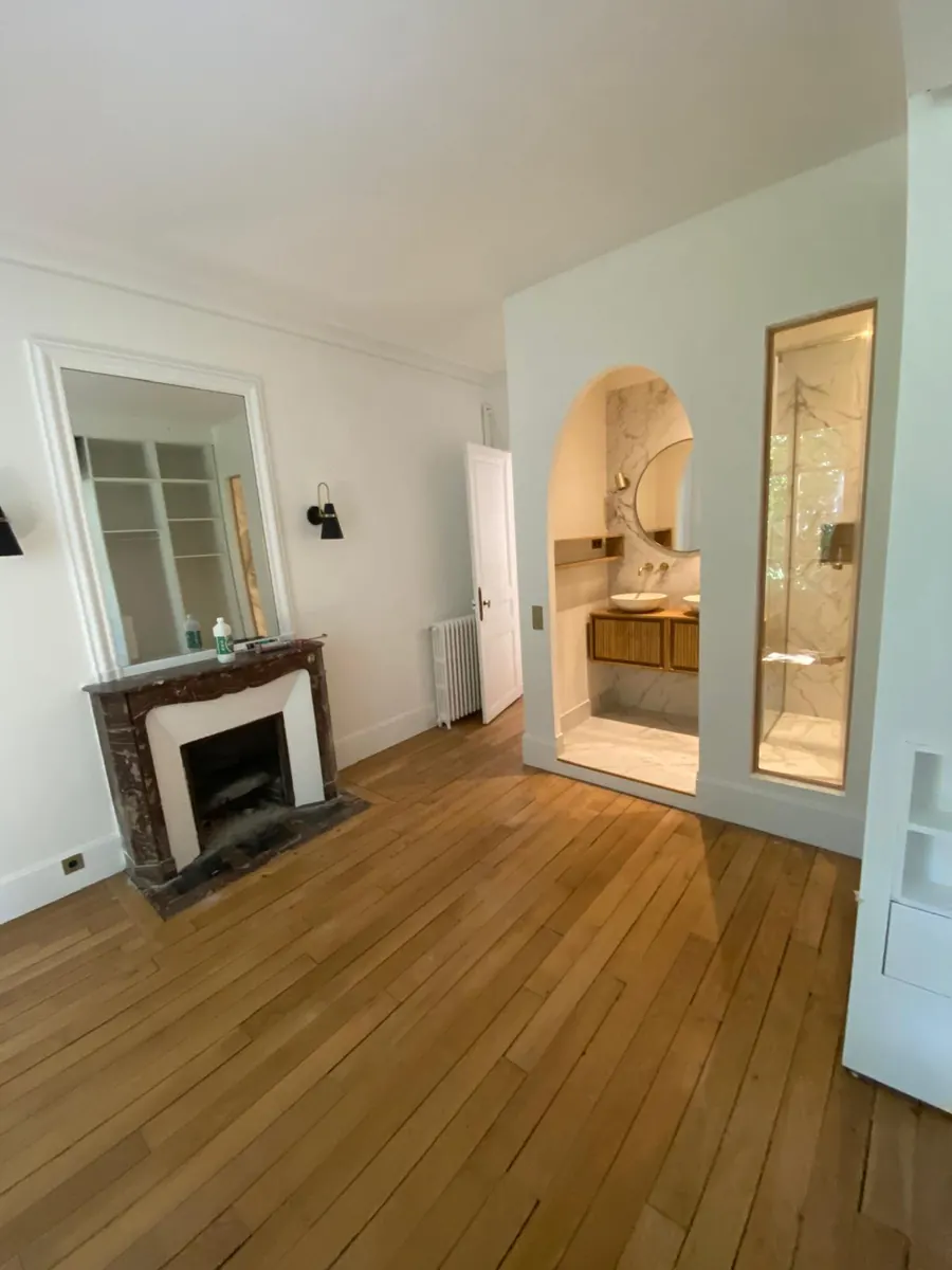 Chambre rénovée avec parquet, cheminée et salle d’eau