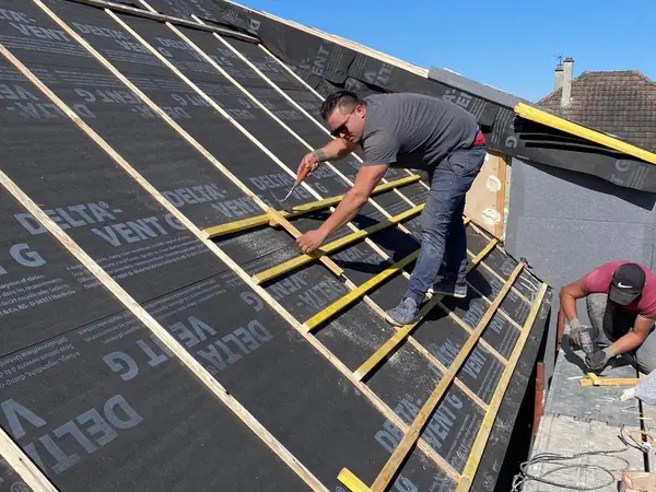 Couvreurs posant les liteaux sur l’écran sous toiture