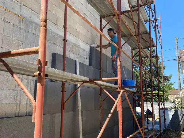 Échafaudage contre un mur pignon en blocs