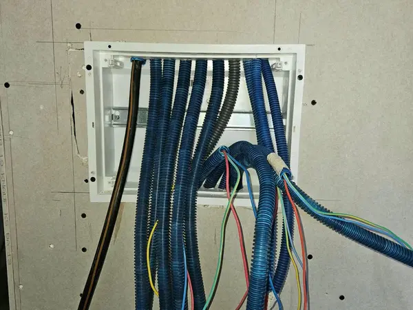 Arrivée des gaines électriques dans un tableau encastré, avant raccordement