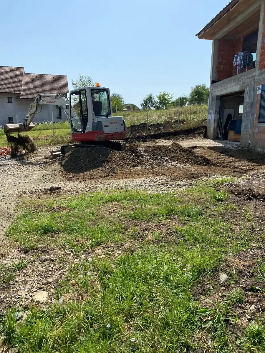 Mini-pelle Takeuchi en terrassement dans un jardin