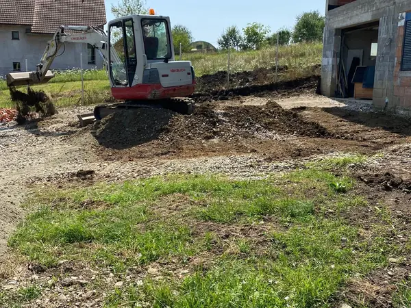 Mini-pelle Takeuchi en terrassement dans un jardin