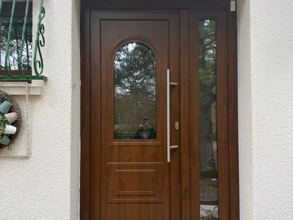 Porte d’entrée ton bois avec vitrage arrondi et fixe latéral