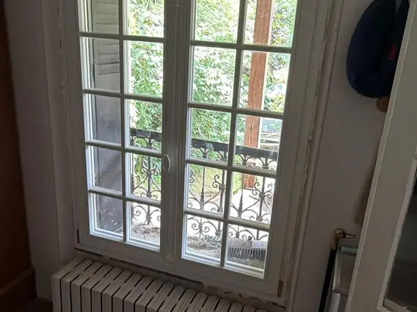 Porte-fenêtre blanche à petits carreaux donnant sur une pergola
