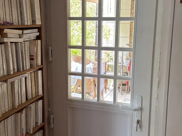 Porte blanche à petits carreaux, vue depuis une bibliothèque