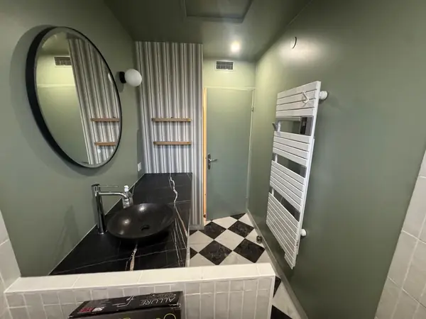 Salle de bain avec sèche-serviettes et plan vasque noir