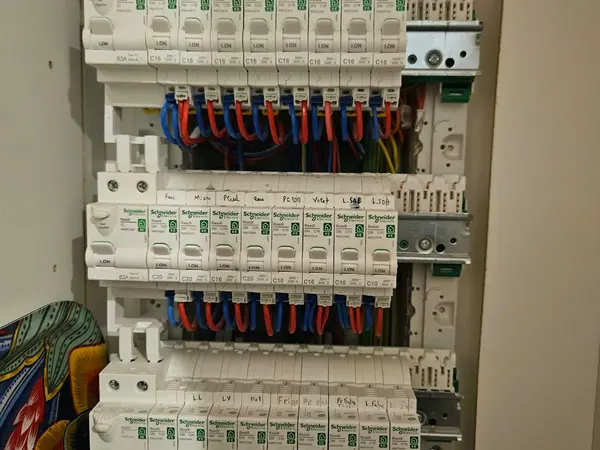 Tableau électrique de trois rangées de disjoncteurs en cours de câblage