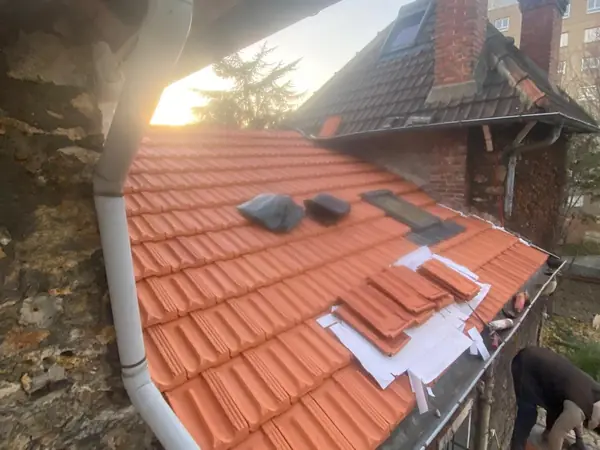 Toiture refaite en tuiles neuves avec fenêtre de toit