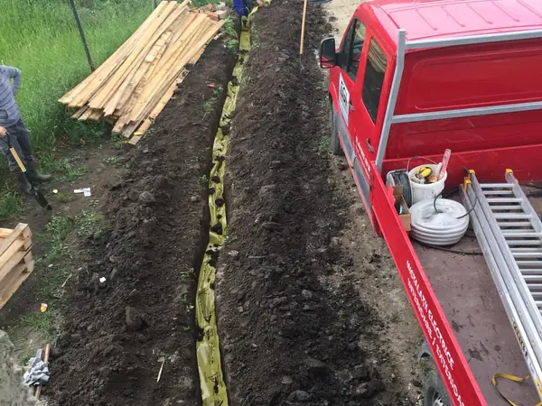 Tranchée avec gaine électrique le long d’un terrain